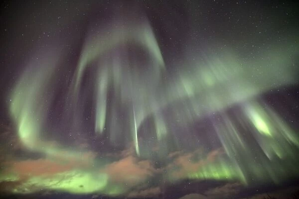 The shapes of green light of the Aurora Borealis color the sky, Lyngen Alps, Troms