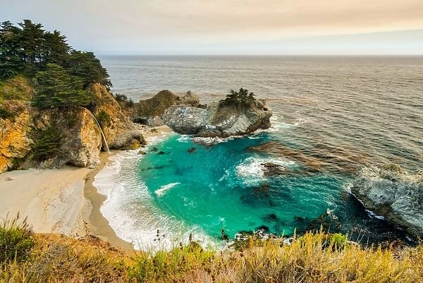 Smoky skies from a nearby wildfire turn the land orange at McWay Falls, California
