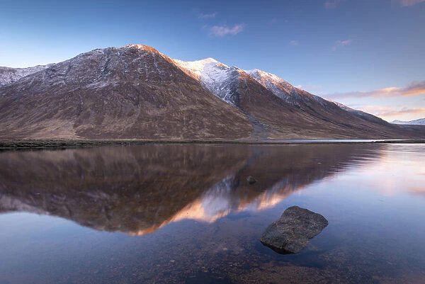 Snow capped Highlands mountains reflected in the calm waters of Loch Etive in winter