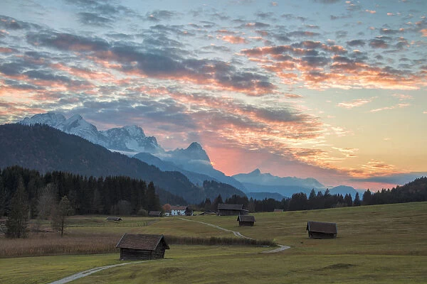 Sunset on wooden huts and meadows with the Alps in background, Geroldsee, Krun, Garmisch