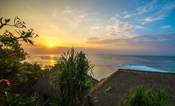 Surfers at sunset in Bali with straw roofed huts, Indonesia, Southeast Asia, Asia