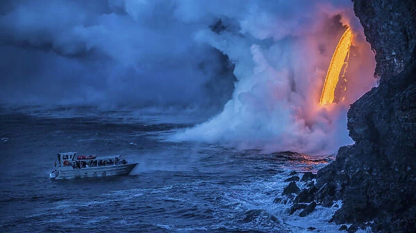 A tour boat observes lava pouring into the sea from 60 feet above as steam plumes billow
