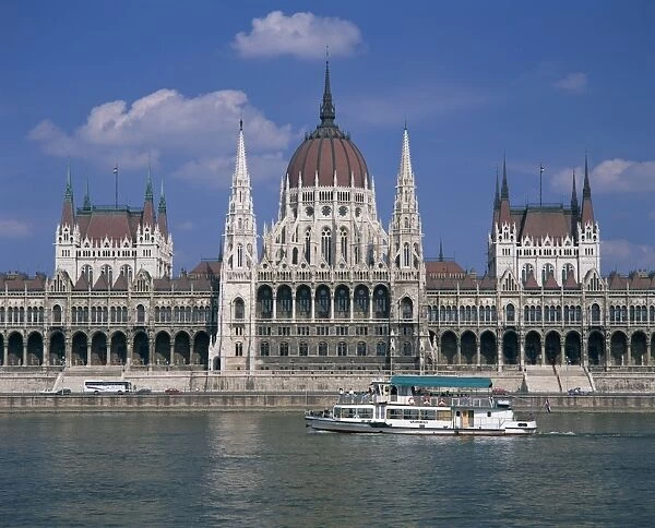 Tourists on a boat on the River Danube pass the Parliament
