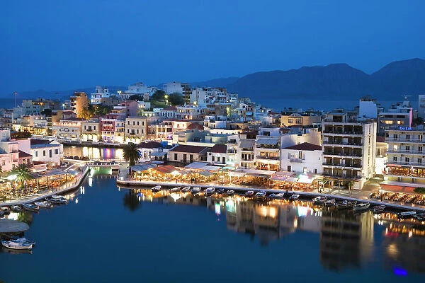View over harbour and restaurants at dusk, Ayios Nikolaos, Lasithi region, Crete, Greek Islands, Greece, Europe