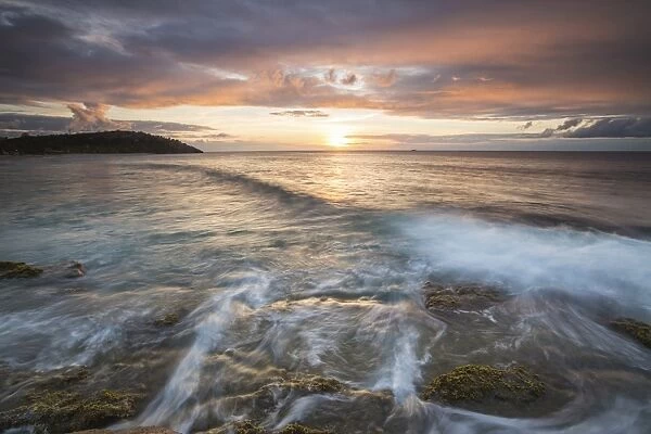 Waves crash on cliffs under a colorful Caribbean sunset, Galley Bay, St. Johns, Antigua