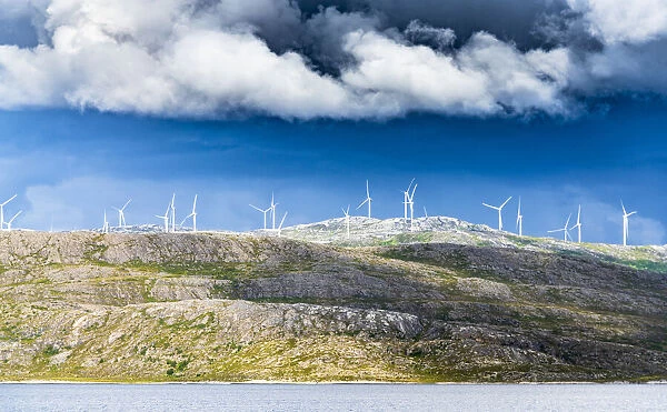 Wind farm of white turbines on rocky coastline, Troms county, Norway, Scandinavia, Europe