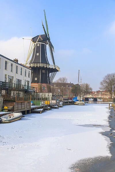 Windmill De Adriaan along the frozen canal of Spaarne river, Haarlem, Amsterdam district