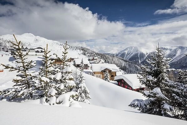The winter sun shines on the snowy mountain huts and woods, Bettmeralp, district of Raron