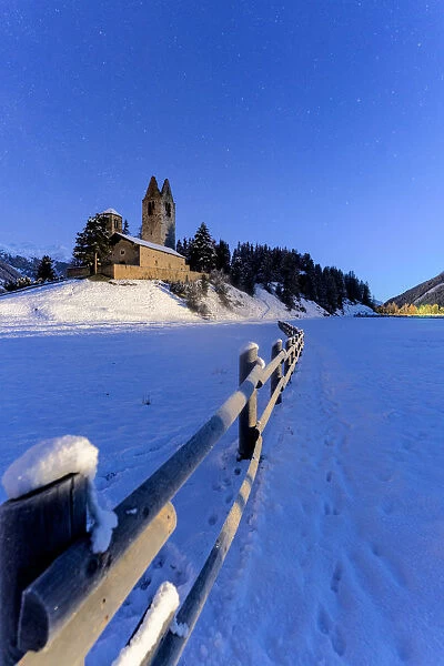 Wood fence in the snow surrounding the church of San Gian, Celerina, St