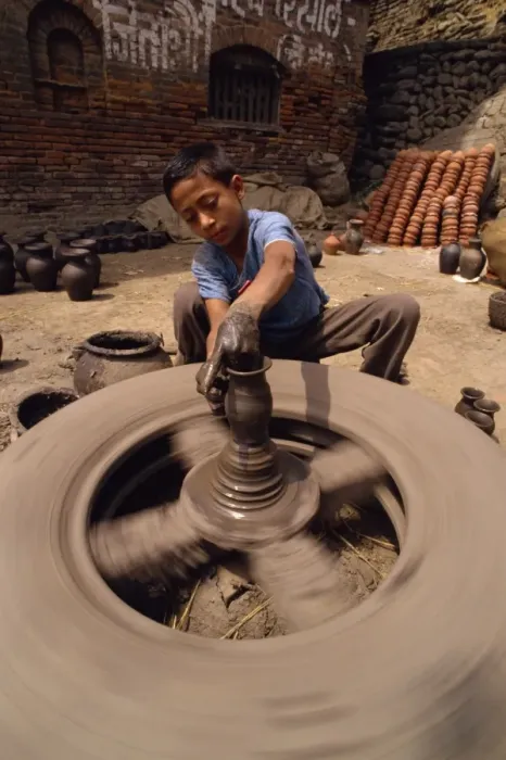 Framed Print : Young boy throwing a pot Print, Nepal Framed Print : Young boy throwing a pot Print, Nepal