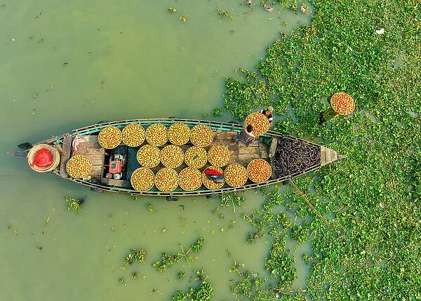 Aerial view of people trading with fruits and vegetables on boats along the river in Brahmanbaria, Bangladesh