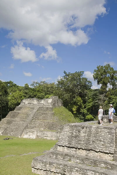 Belize, Caracol ruins, Plaza A, Ladies standing on Structure A6 - Temple of the Wooden