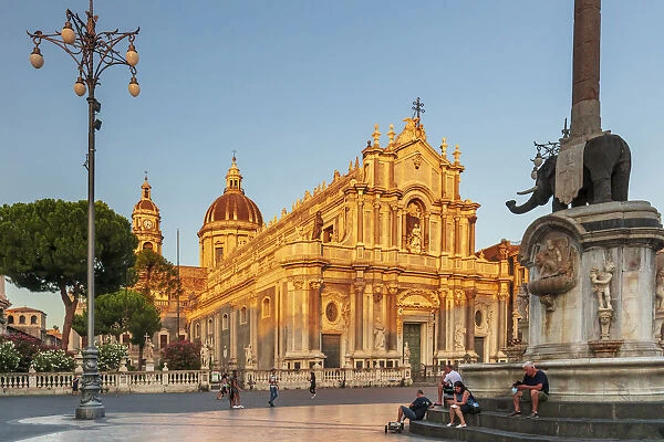 Catania, Sicily. People walking on the main square at sunset with the Cathedral in the
