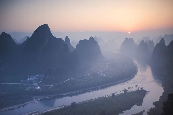 China, Guanxi, Yangshuo. Sunrise over Li river and karst peaks, elevated view