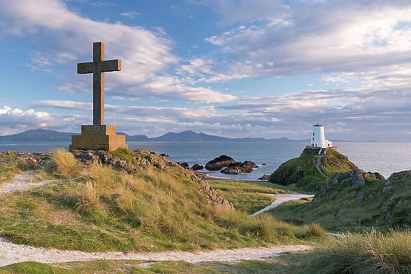 Cross and lighthouse on Llanddwyn Island, Anglesey, Wales. Autumn (September)