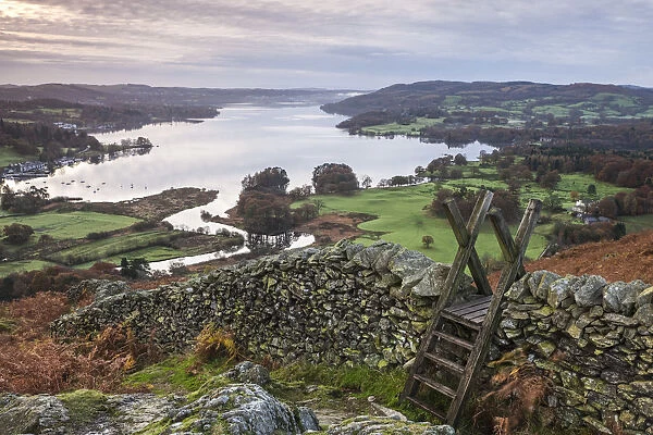 Dry stone wall and wooden stile above Lake Windermere, Lake District, Cumbria, England