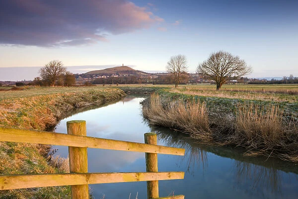 First light of morning on Glastonbury Tor viewed from the River Brue on the Somerset