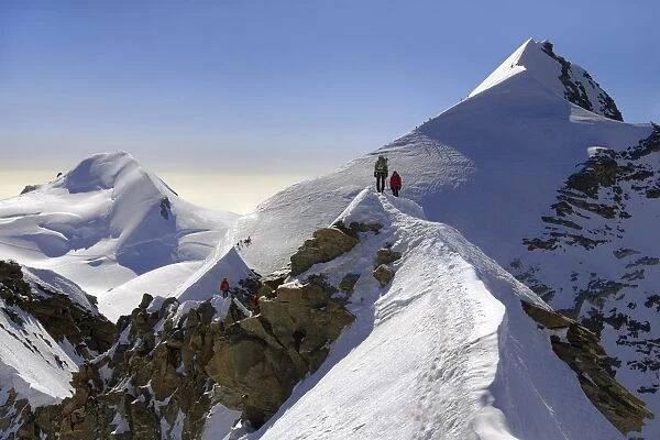 Mountaineers climbing sharp ridge of ‚Aucrossing of Liskamm‚Au, (traversata dei Lyskamm) Monte Rosa, Ayas Valley, Aosta Valley, Italy