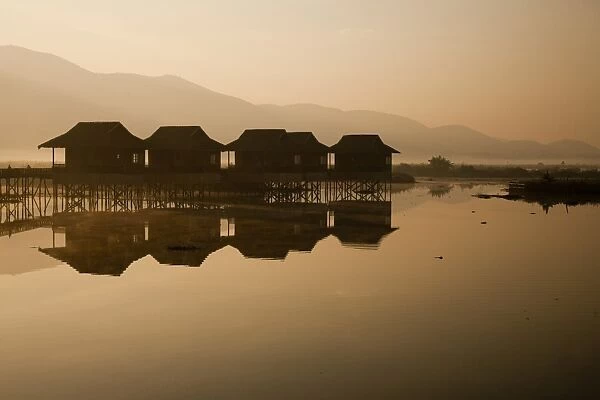 Myanmar, Inle Lake. A misty dawn at Golden Island Cottages, a resort for tourists owned by the Pa-O people, a collection of comfortable wooden huts on stilts