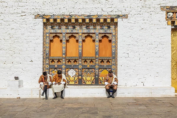 People sitting at the Punakha Tshechu (otherwise known as Punakha Festival)