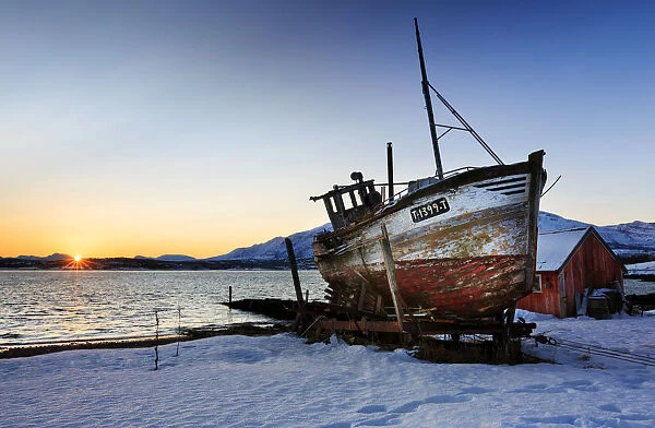 Shipwreck on the shore of Tromso fiord at sunrise, troms, norway