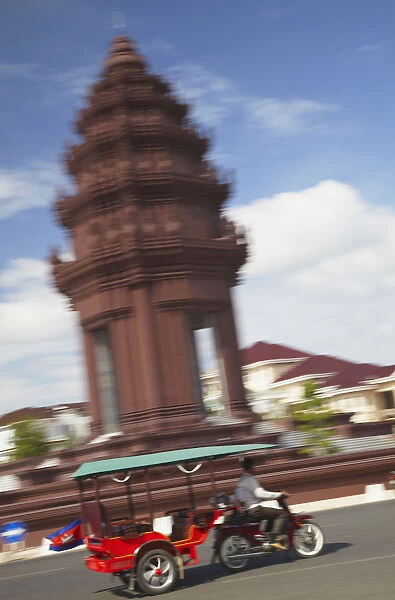 Tuk tuk passing Independence Monument, Phnom Penh, Cambodia