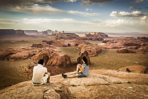 Utah - Ariziona border, two young tourists watching the panorama of the Monument Valley