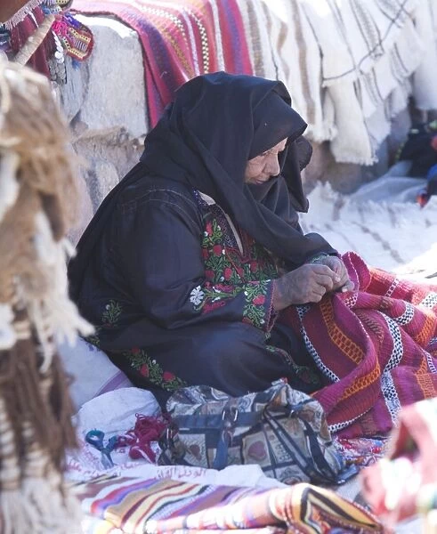 An arabic women in Dahab on the Red Sea in the Sinai Desert Egypt making goods