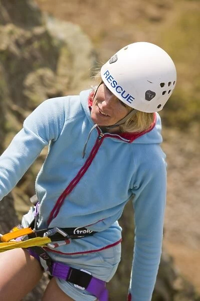 a female member of Langdale Ambleside Mountin rescue team abseiling UK