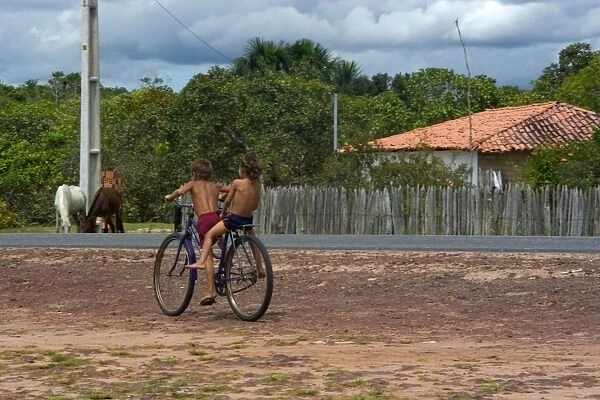 Kids cycling around highway, Sangue, Maranhao, Brazil