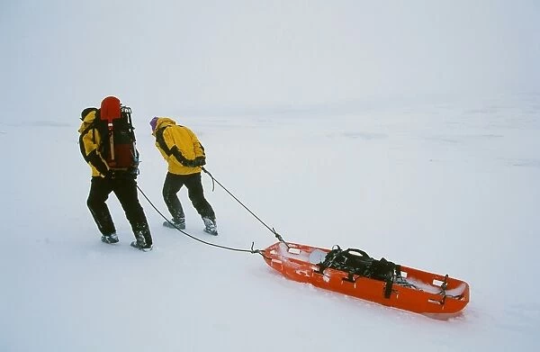 Mountain Rescue team members drag a sled across the Scottish mountains