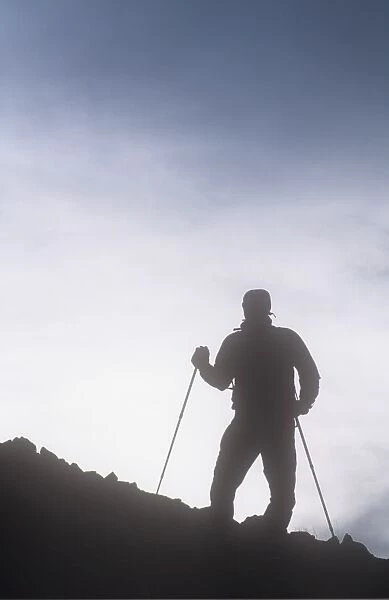 A mountaineer using wallking poles in the Lake District, UK
