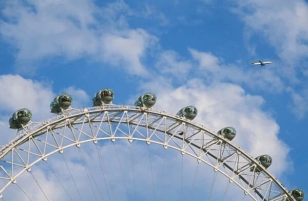 A plane flying over the London Eye in london UK