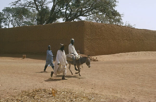 20040902. NIGERIA Kano Street scene with two men walking beside a man on a donkey