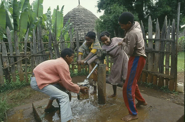 20070894. ETHIOPIA Attat Group of laughing children collecting water at hand pump