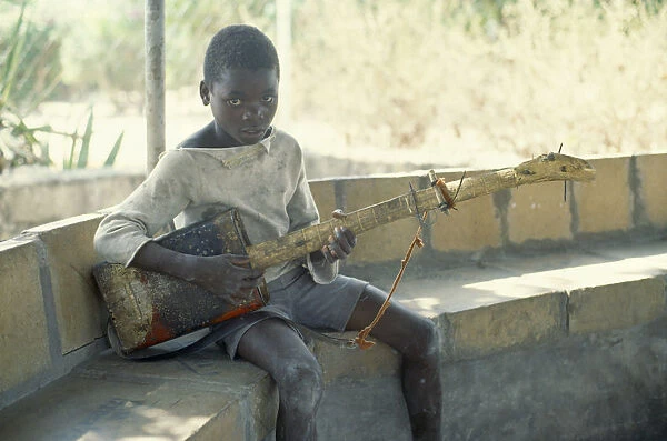 20071934. ZAMBIA Chingola Boy with guitar made from oil can and piece of wood. recycled