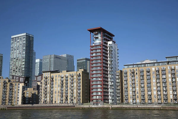 England, London, Isle of Dogs, Thames riverside blocks with Canary Wharf in background