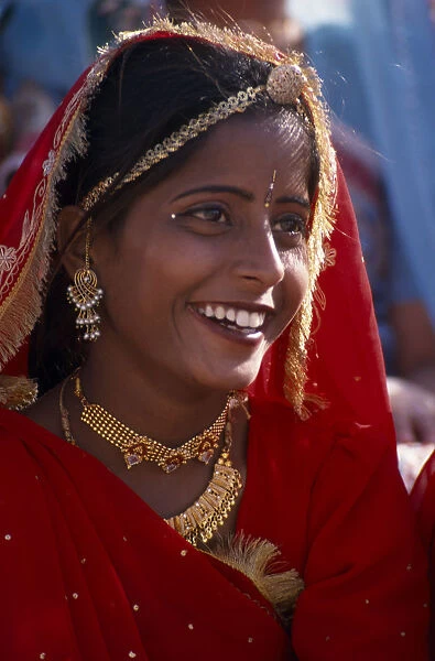 INDIA, Rajasthan, Bikaner Portrait of a girl dancer smiling wearing red