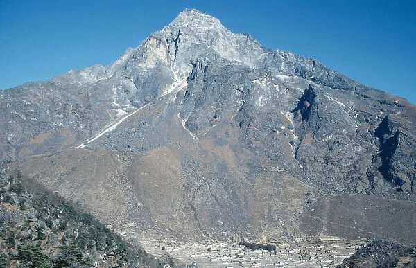 Nepal, Khumbu, Village near Namche bazar at foot of jagged, barren mountain with scree slopes cris-crossed with narrow tracks and crevices