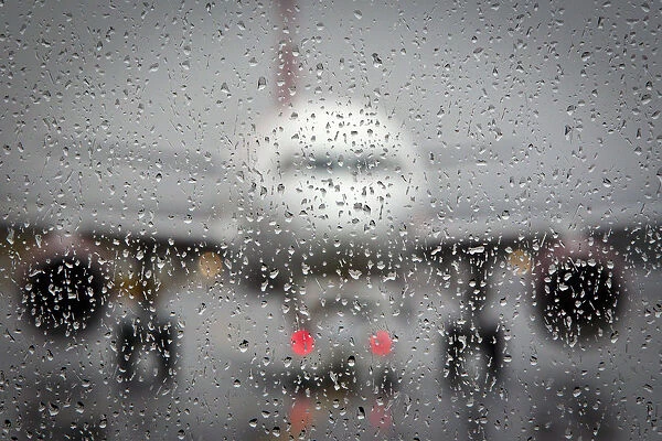 Airplane is pictured though a rain-coated window on the day before Christmas at LaGuardia