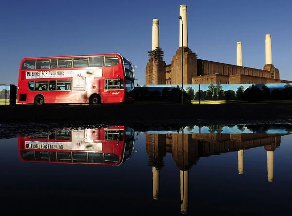 Battersea Power Station is seen reflected in water in west London