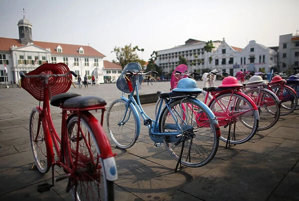 Brightly-painted old bicycles are lined for tourists to rent near the History museum