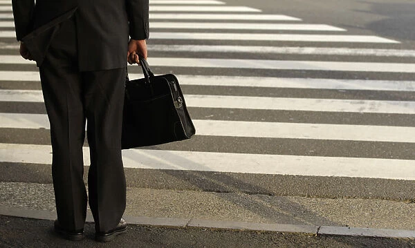 A businessman waits to cross a street in Tokyo