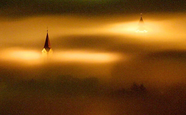 CHURCH TOWERS PEAK THROUGH HEAVY NIGHT TIME FOG IN LIPTOVSKY MIKULAS