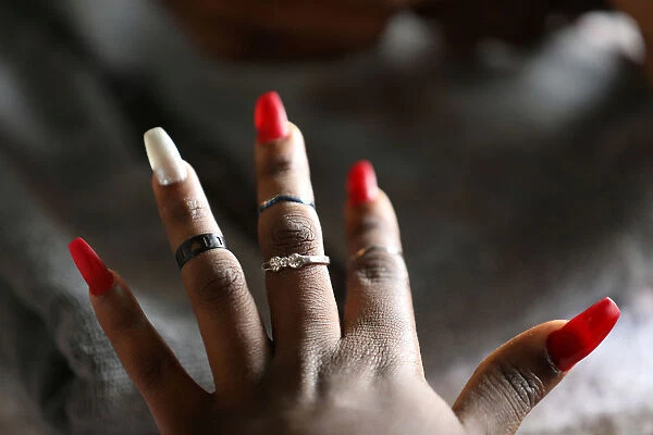 A client presents her nails after they have been painted on Valentines Day at Wuse