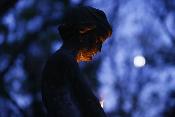 A grave monument is lit by candle light at the Powazki cemetery in Warsaw