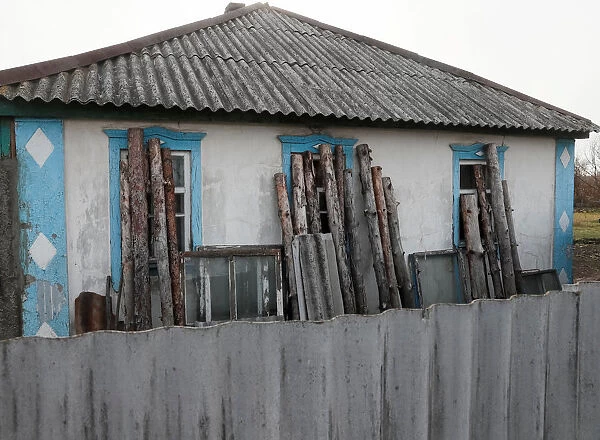 A house with windows covered with wood to protect from shrapnel is seen in the village of