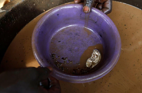 An informal gold miner adds mercury to panned material to suck the gold out of the dirt