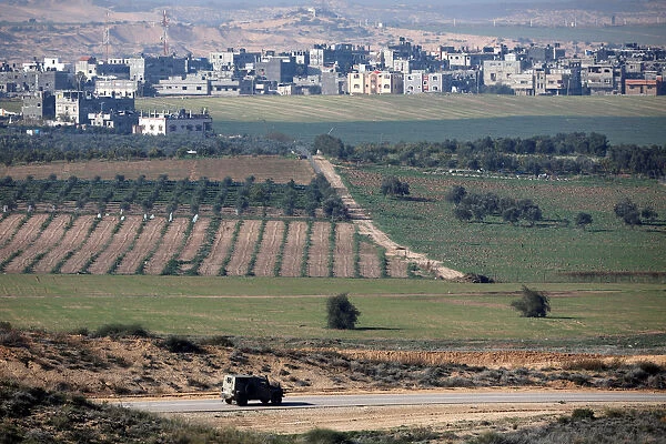 An Israeli military jeep drives along the Israeli side of the border with the northern