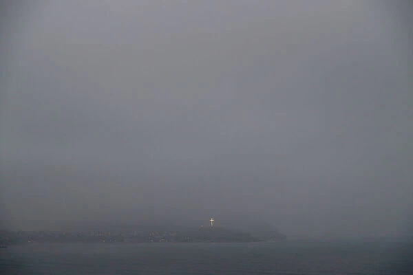 The lighted cross of Chorrillos is seen from a cliff overlooking the Pacific ocean
